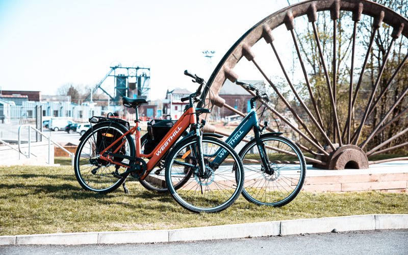 Two e-bikes parked against the backdrop of Snibston Colliery Park, Coalville, Leicestershire. For cycling, e-bikes and e-bike loans.