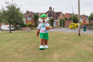 Theo the Fox, the Choose How You Move schools' mascot, walking across a park in a Leicestershire village
