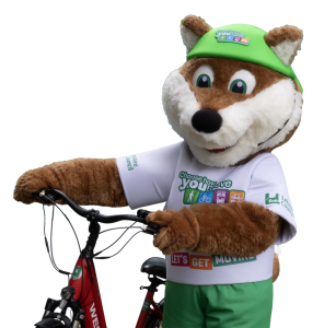 Theo the Fox, the Choose How You Move mascot, stands next to a bike