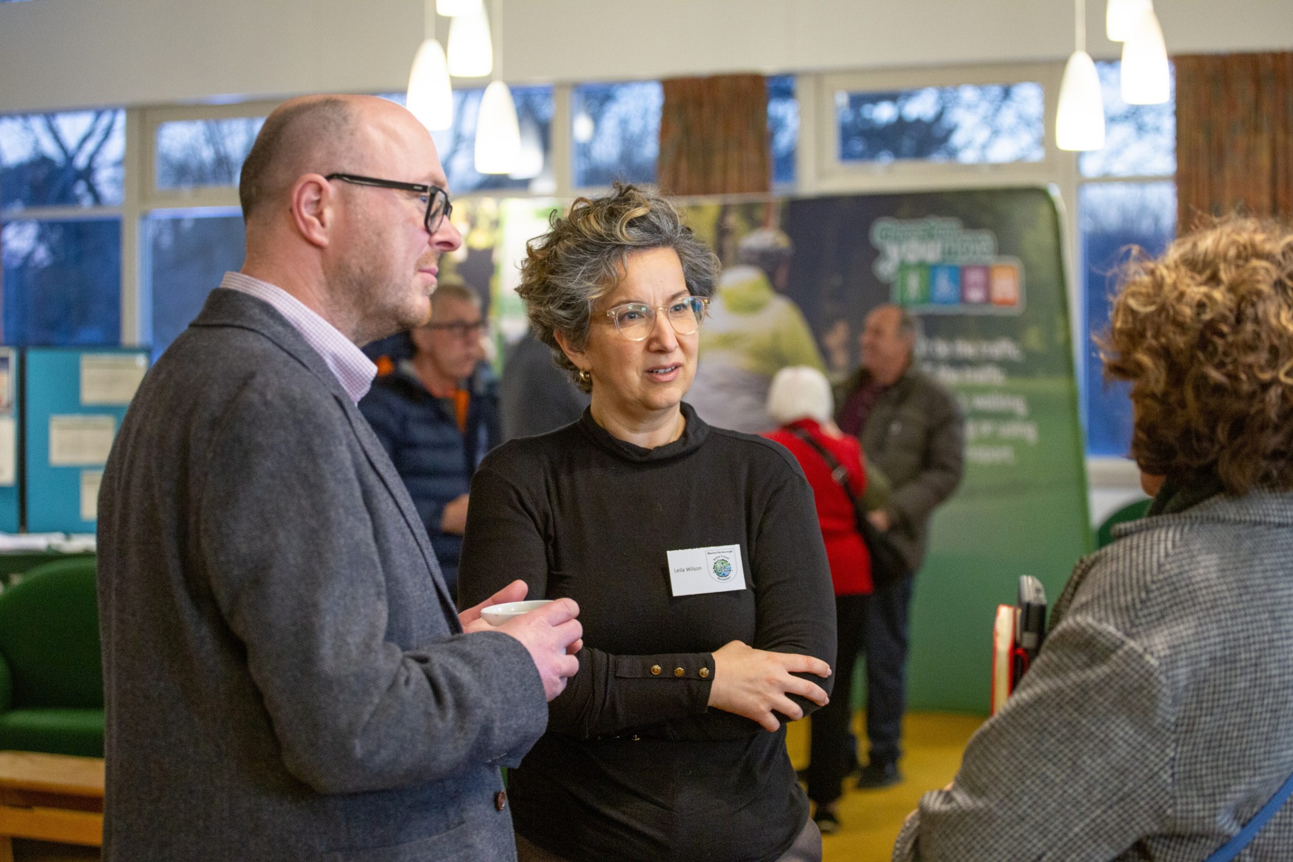 A man and a woman talking amongst stalls at the Cycling, Walking and Wheeling Forum