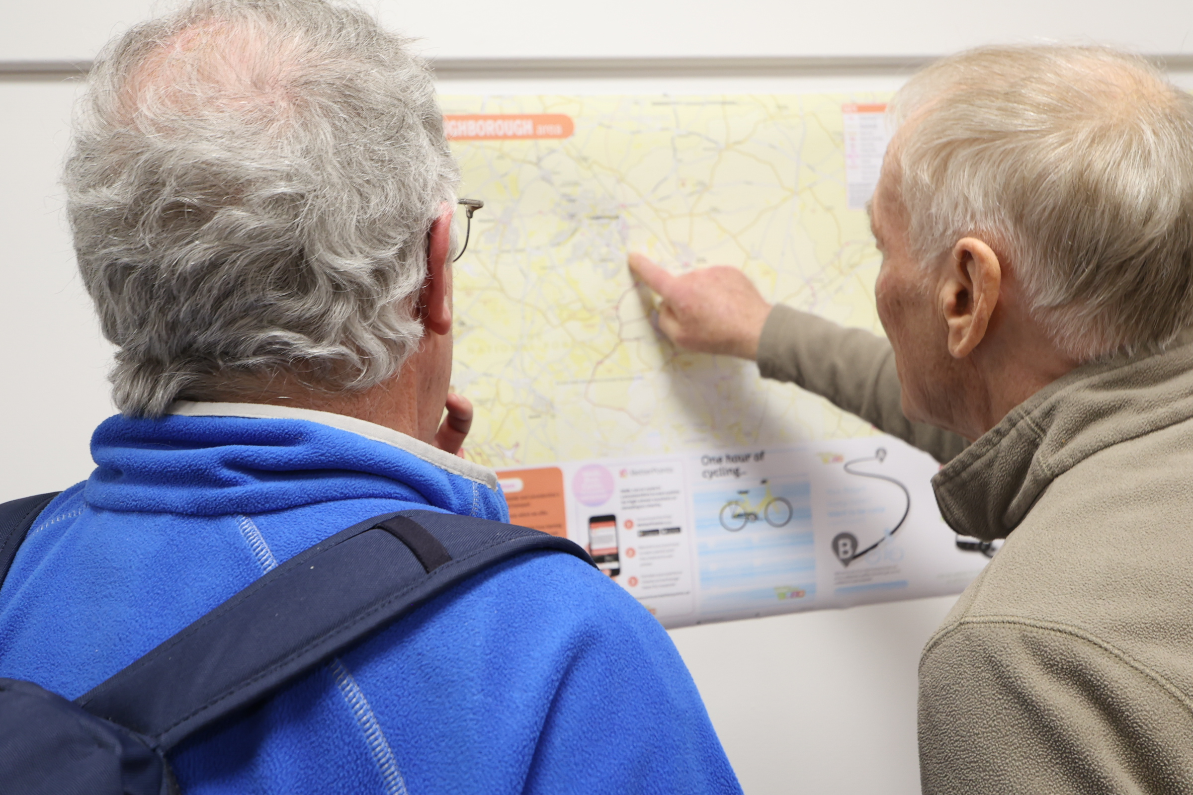 Two people pointing to a map of Loughborough on the wall, for promoting Legacy Grants in Leicestershire communities
