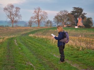 a woman walking in a field with a map