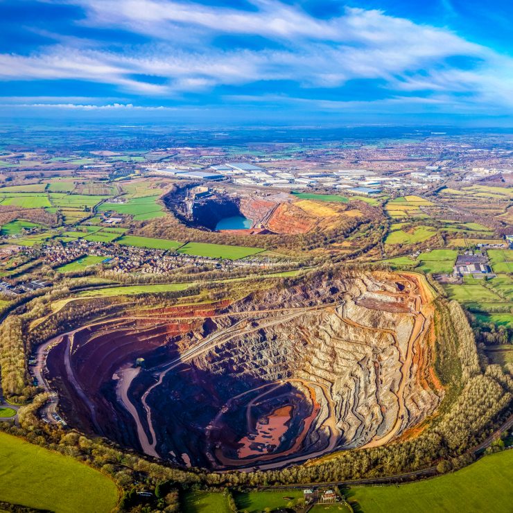 Drone panorama of a vast open pit quarry carved into rolling green countryside near Coalville, Leicestershire; perfect for mining, infrastructure, land use, and sustainability visuals Aerial view of an open-pit quarry and industrial landscape near Coalville, North West Leicestershire.