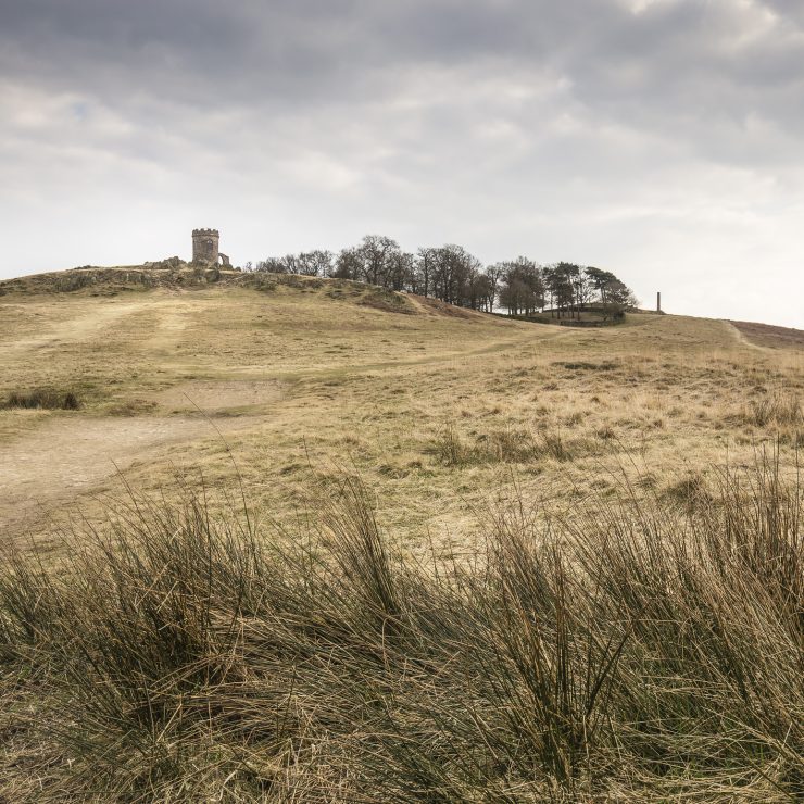 Bradgate Park, Leicestershire, England - 25 March 2015: An image shot on a grey day showing the landscape in Bradgate Park, Leicestershire England, UK. A grassy hill at Bradgate Park with a stone outhouse, Old John, at the top. For Charnwood borough.