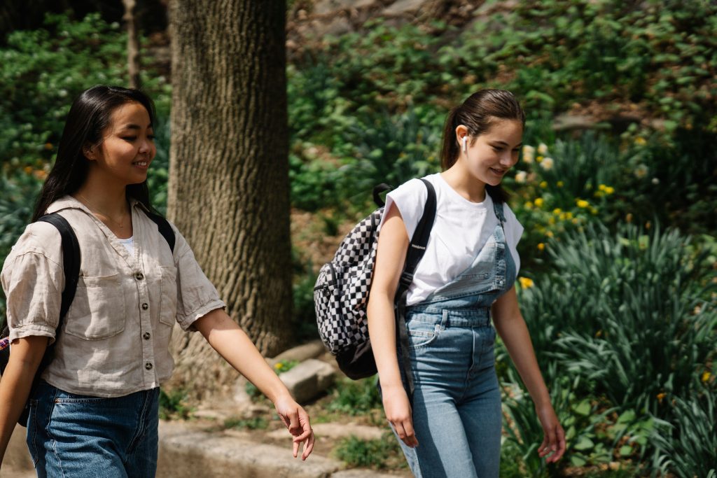 Two teenage girls with backpacks walking - for schools and Active Travel Calendar