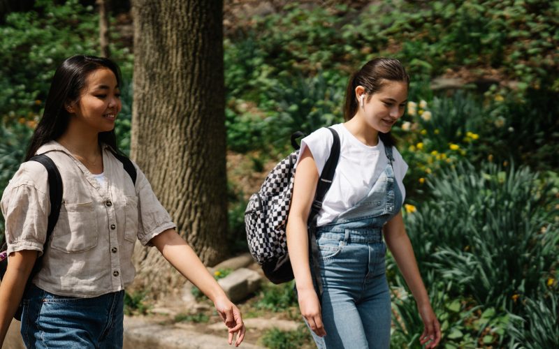 Two teenage girls with backpacks walking - for schools and Active Travel Calendar