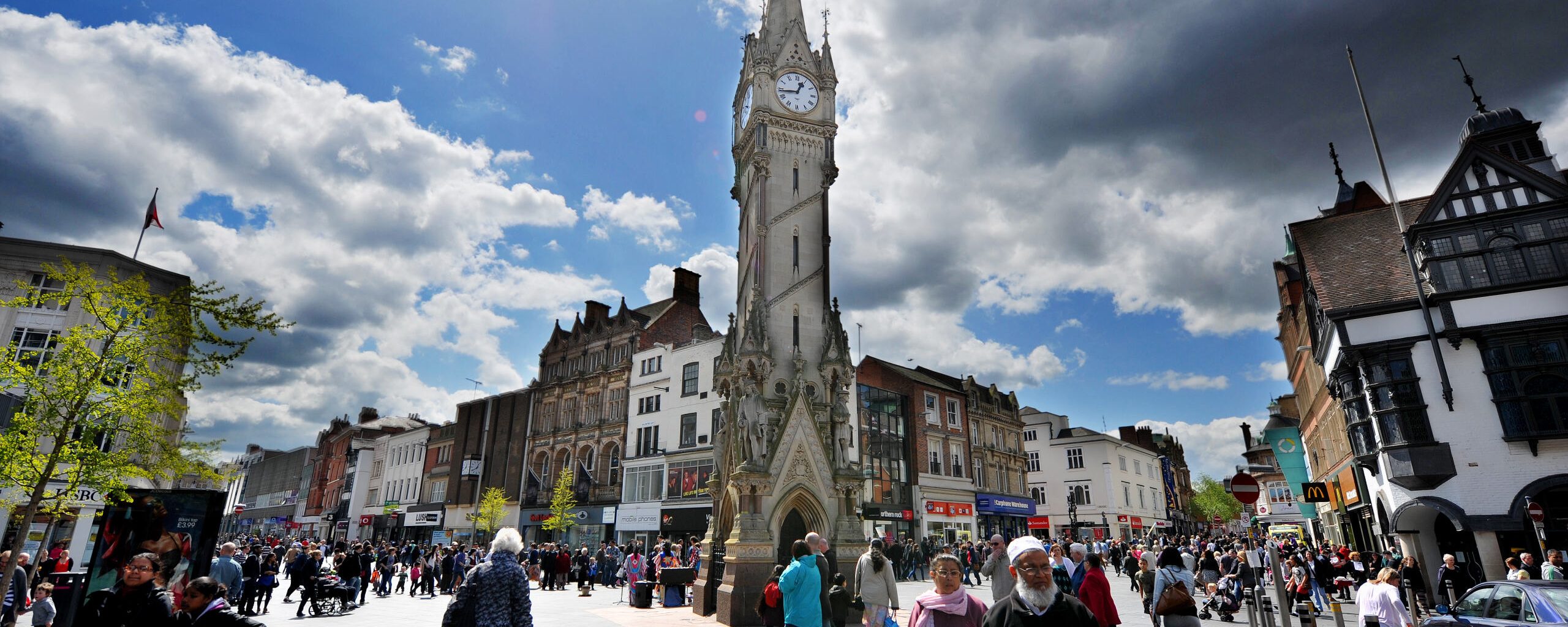 People walking near Leicester Clock Tower.