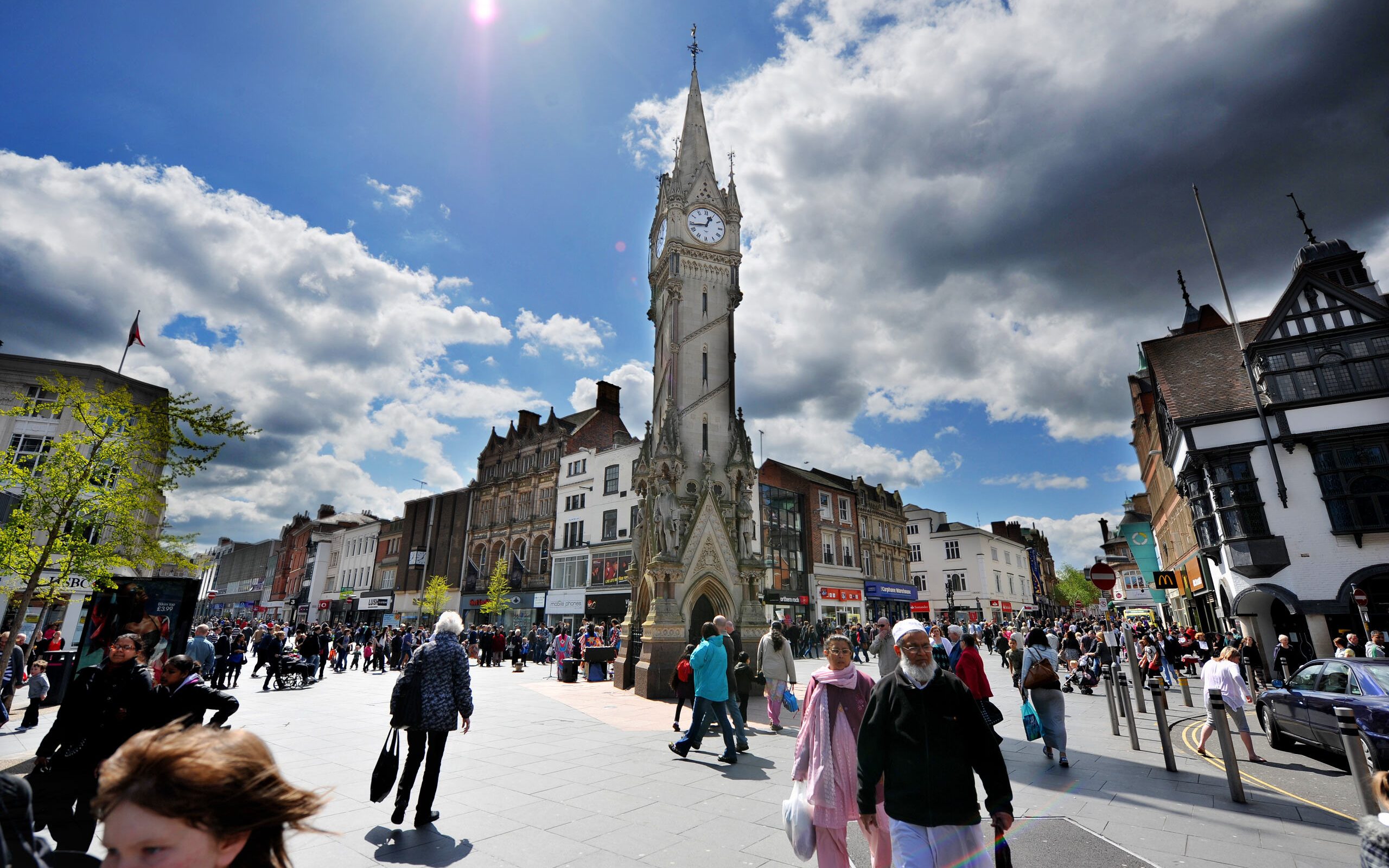 People walking near Leicester Clock Tower.