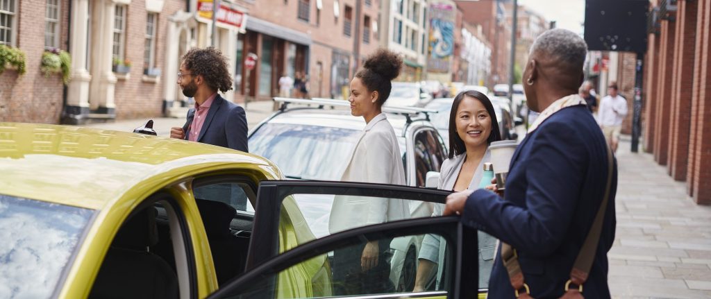 A group of four workers getting out of a car. For car sharing, commuting, Leicestershire Businesses, business programme.