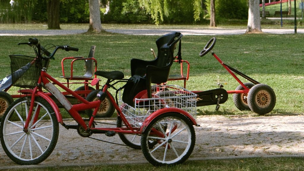 Adapted bikes parked in a park. For adaptive travel, adaptive bikes and scooters and accessible transport.
