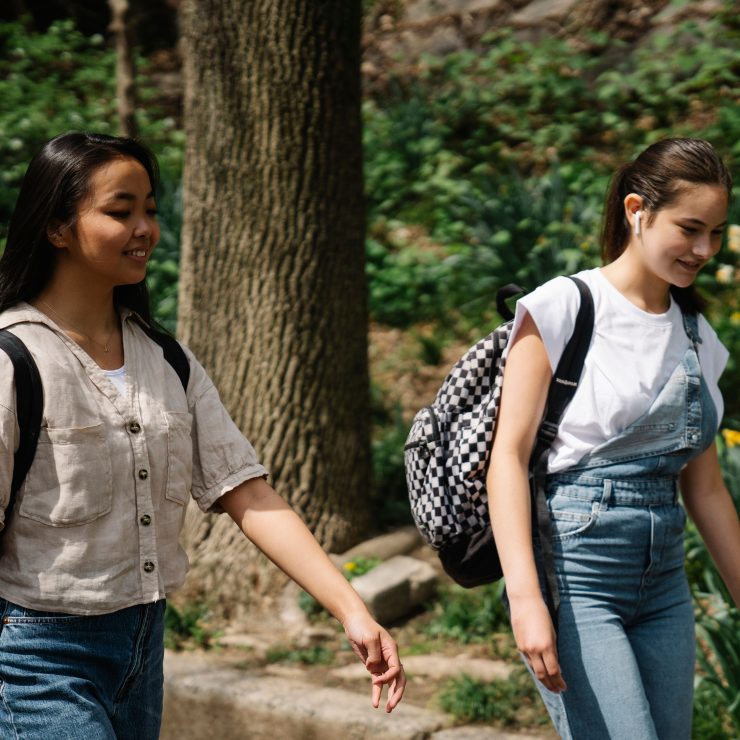 Two teenage girls with backpacks walking - for schools and Active Travel Calendar