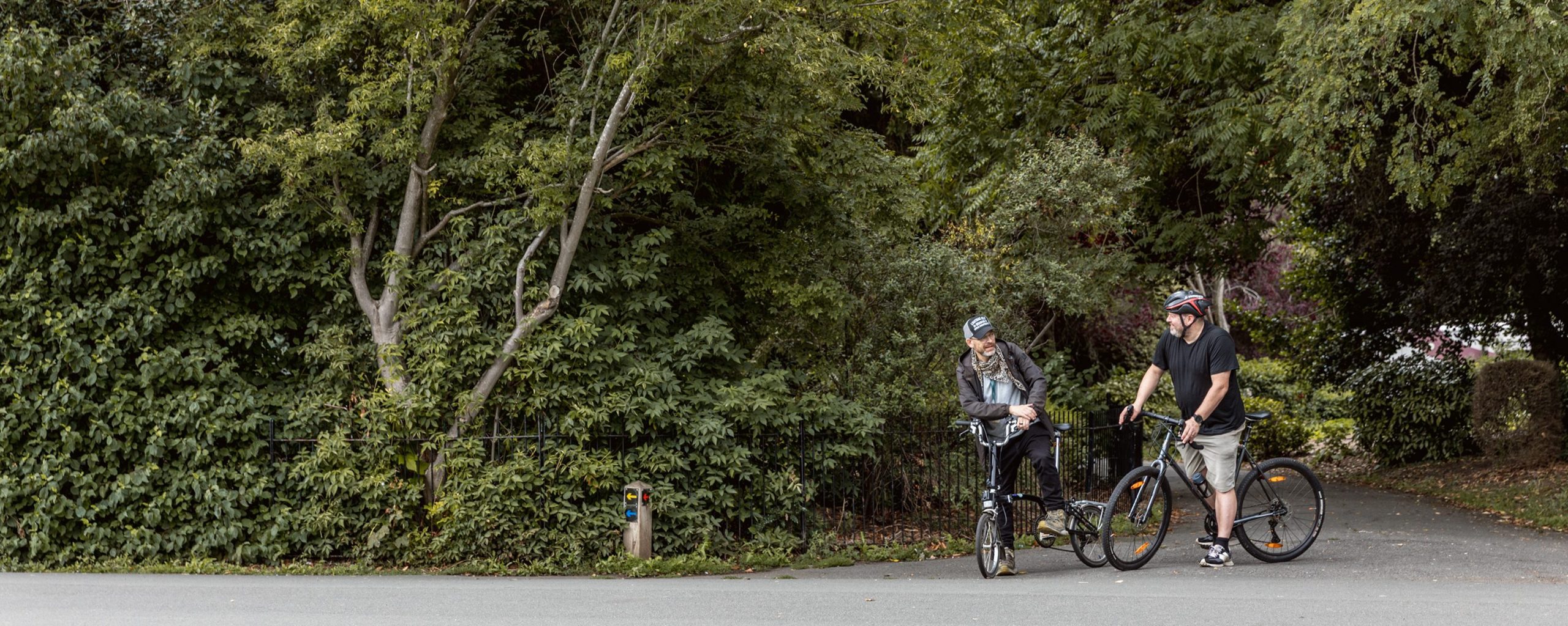 People travelling by bike through a Leicester city park.