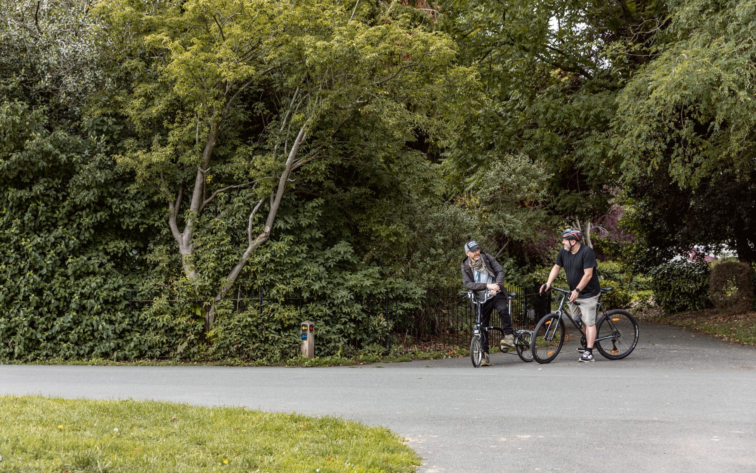 People travelling by bike through a Leicester city park.