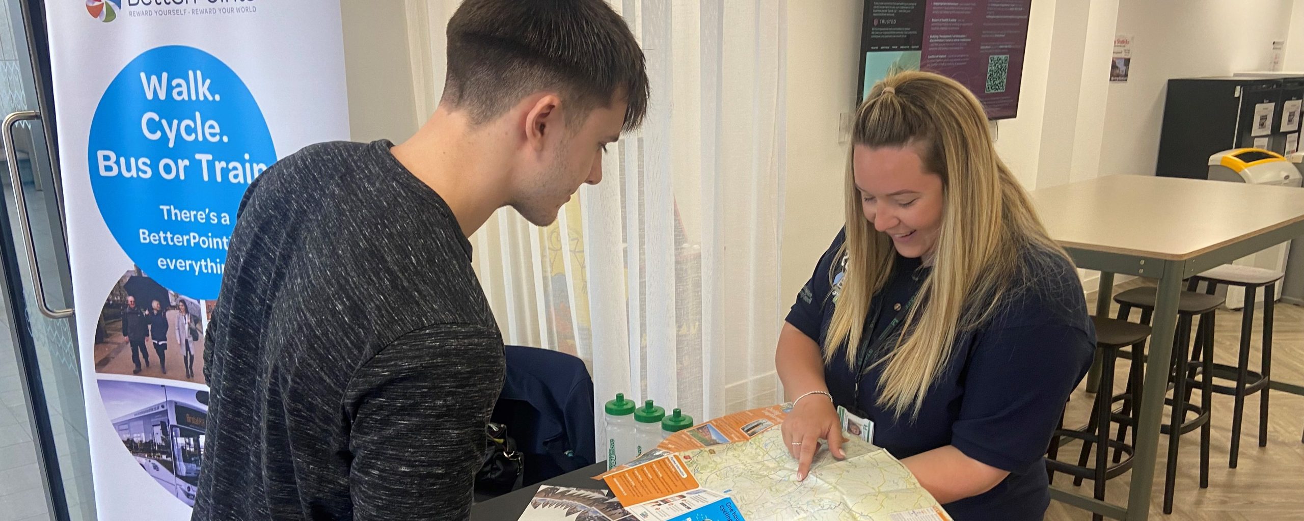 staff at an event showing a customer the cycle map for communities and events such as community roadshows
