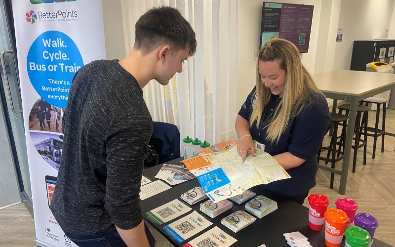 staff at an event showing a customer the cycle map for communities and events such as community roadshows